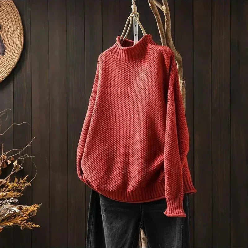 Pull rouge en maille texturée à col montant, présenté sur cintre