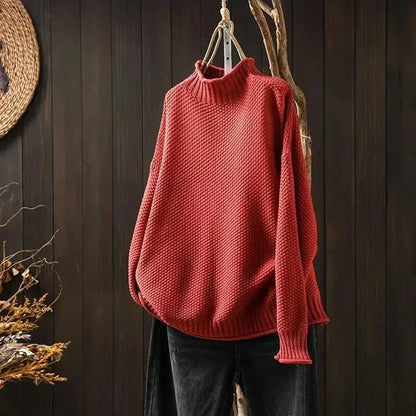 Pull rouge en maille texturée à col montant, présenté sur cintre