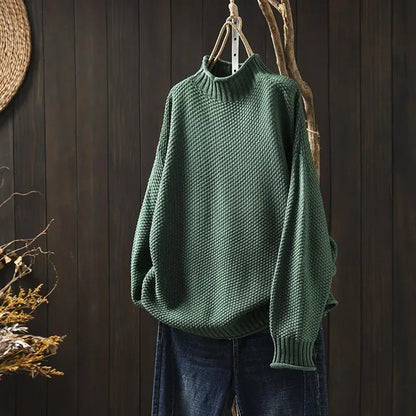 Pull vert en maille texturée à col montant, présenté sur cintre