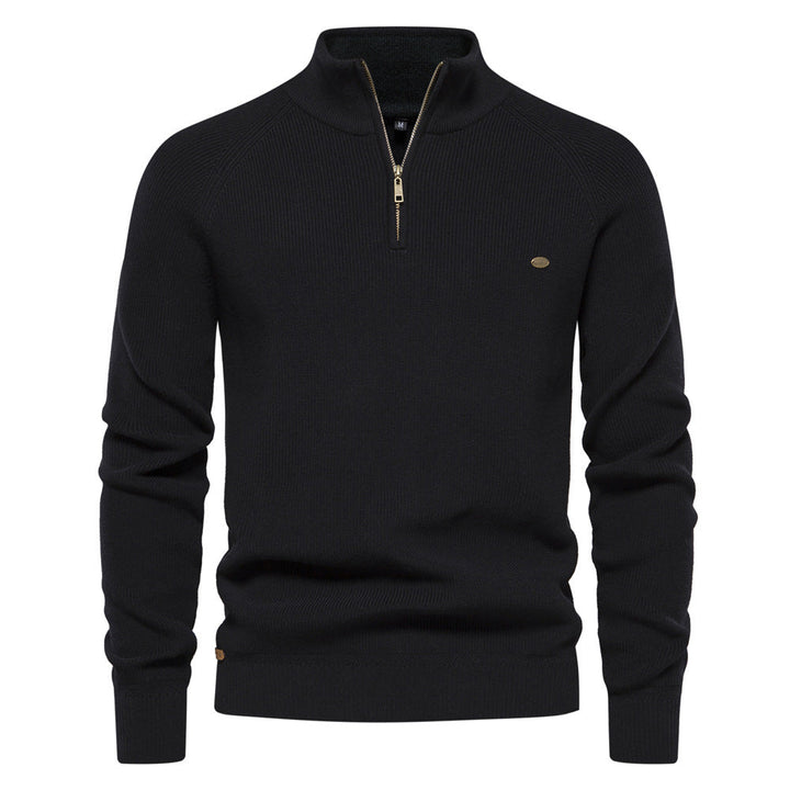 Pull noir à col montant zippé, maille côtelée et petit écusson sur la poitrine