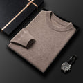Pull col rond beige plié dans une boîte, col et poignet côtelés