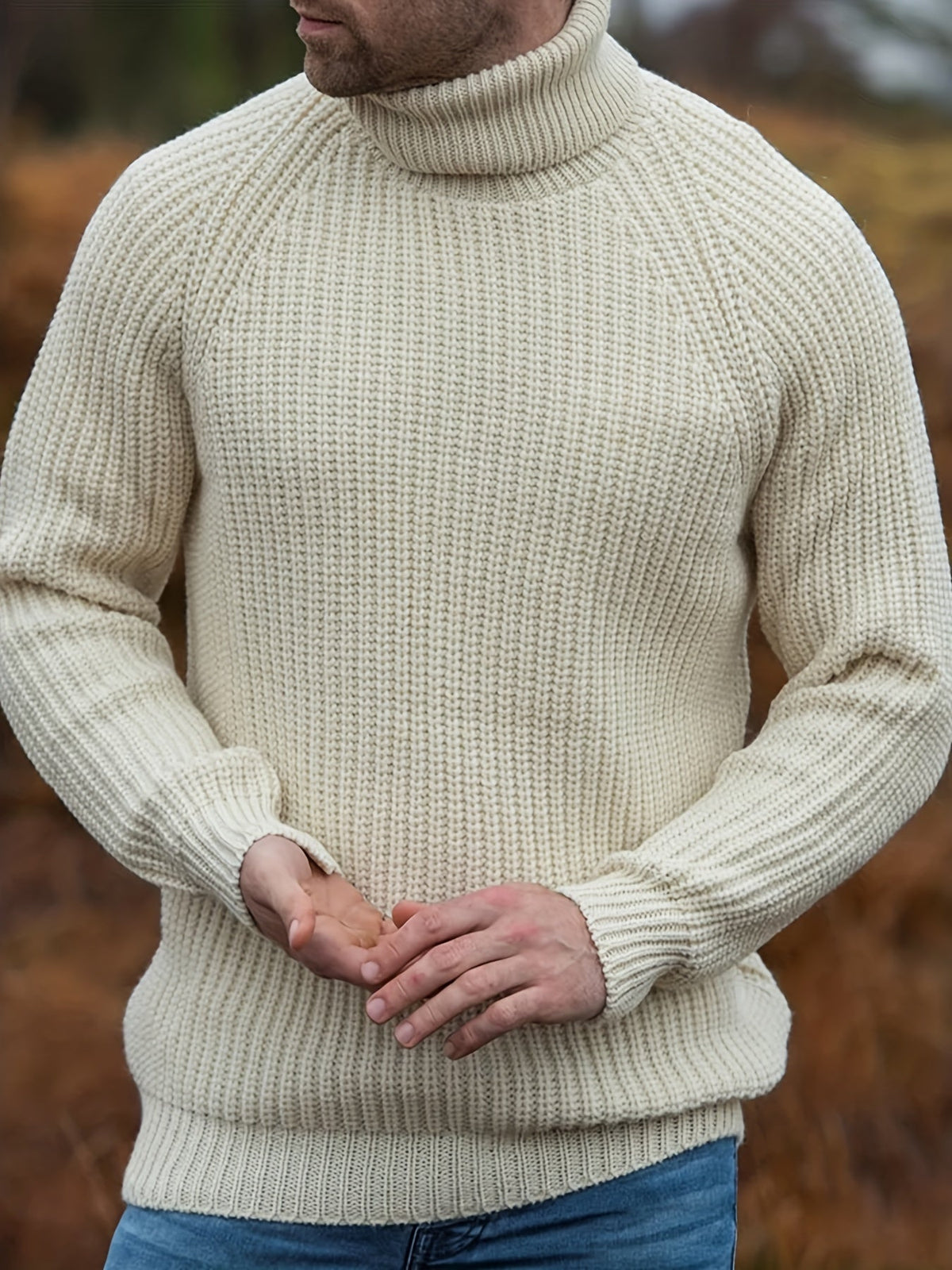 Pull col roulé beige porté, détail des côtes et des poignets