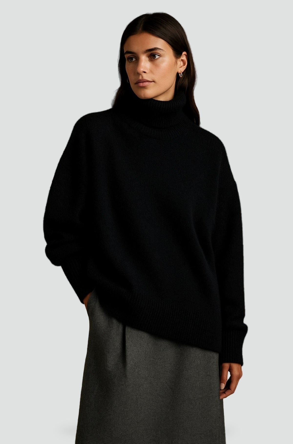 Pull col roulé noir en maille fine, porté avec une jupe grise