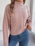 Pull court à torsades, coloris rose poudré, porté en tenue