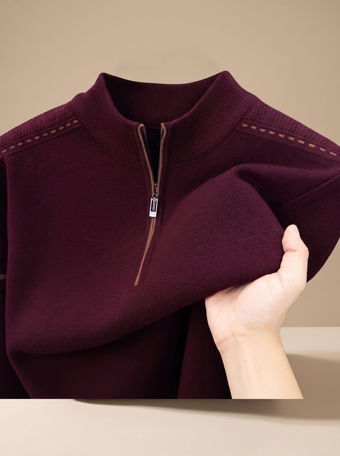 Col montant zippé d'un pull bordeaux, points sur les épaules