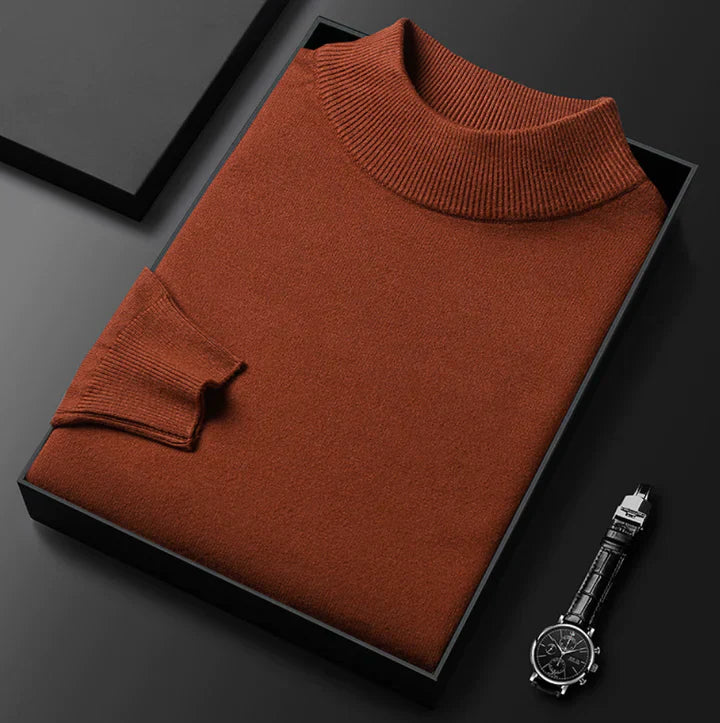 Pull terracotta à col montant côtelé, plié dans un écrin noir avec une montre
