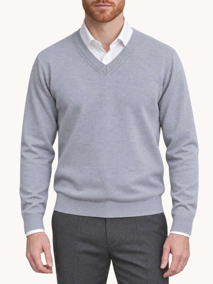 Pull en maille gris perle col V porté avec chemise blanche