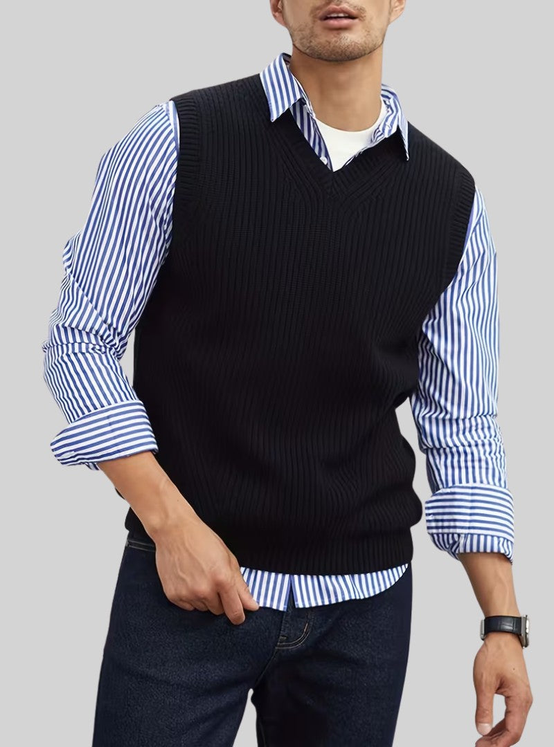 Débardeur en maille noire à col V porté sur une chemise à rayures bleues et un jean