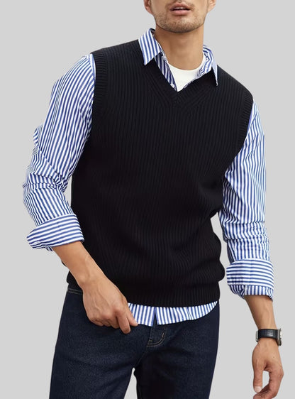 Débardeur en maille noire à col V porté sur une chemise à rayures bleues et un jean
