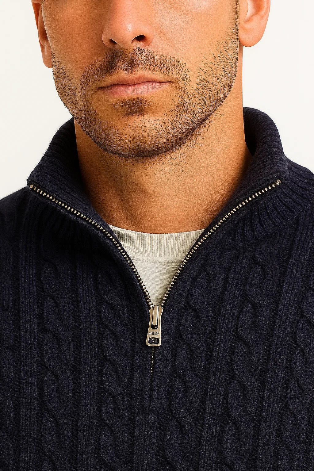 Gros plan sur le col zippé d'un pull torsadé bleu marine