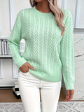 Pull torsadé encolure ronde, coloris vert clair, porté en tenue