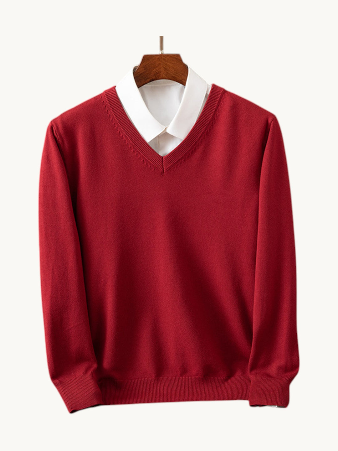Pull en maille rouge col en V avec chemise blanche intégrée, vue de face sur cintre