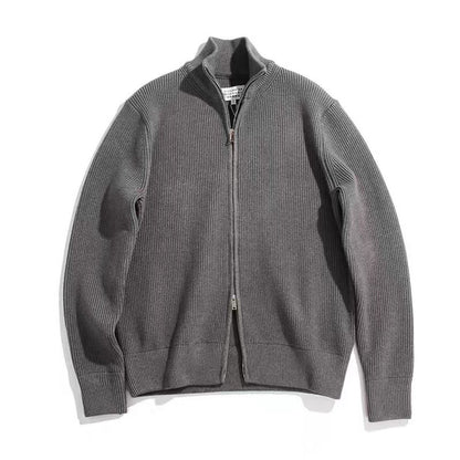 Cardigan gris en maille côtelée à col montant et double zip, posé à plat sur fond blanc