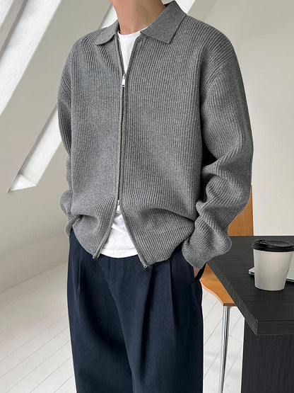 Veste en maille côtelée grise à col et zip, portée avec un pantalon marine