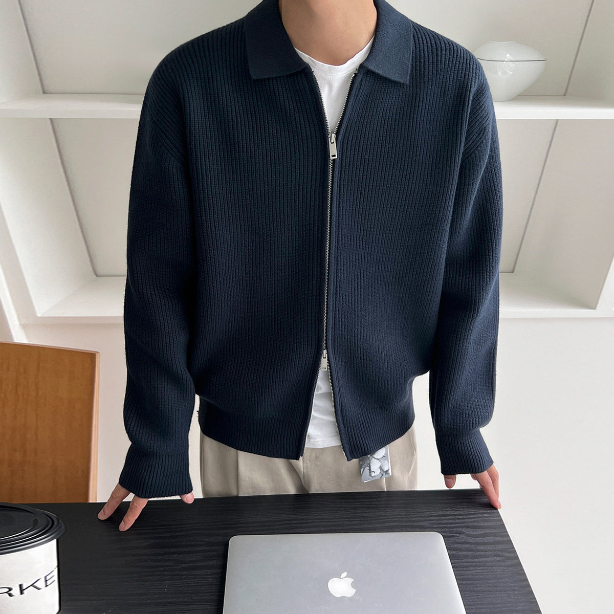 Veste en maille côtelée bleu marine à col chemise et zip, portée ouverte