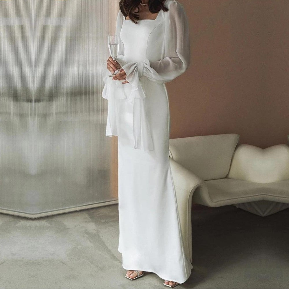 Robe longue blanche à poignets volantés noués, portée en intérieur