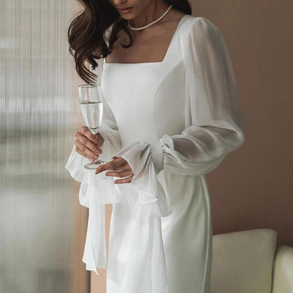Robe blanche à encolure carrée, détail des poignets volantés
