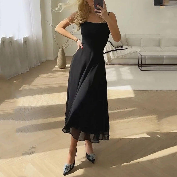 Robe midi noire évasée portée avec des escarpins