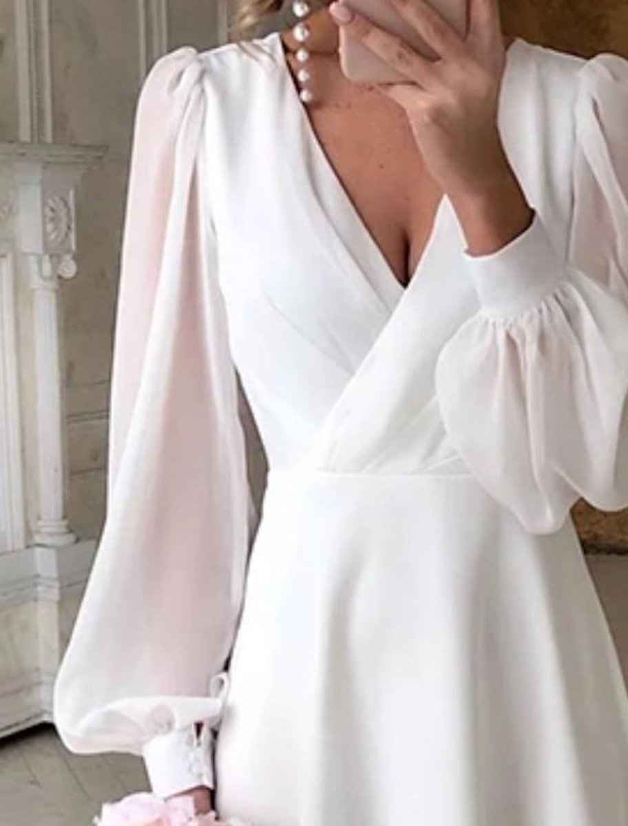 Décolleté en V croisé et manches transparentes de la robe blanche