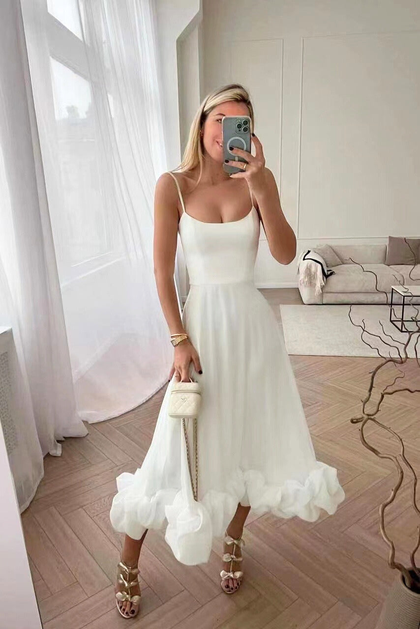 Robe blanche à fines bretelles et ourlet volanté, portée