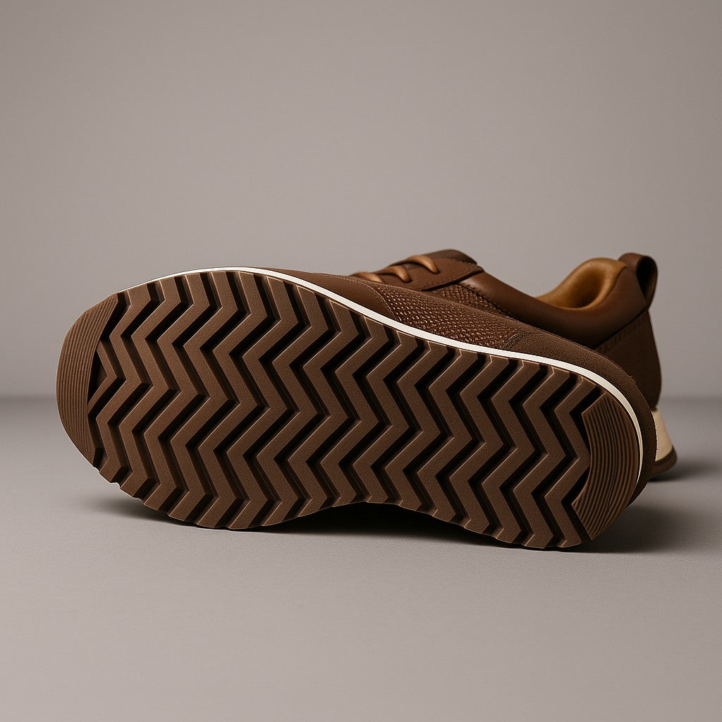 Sneaker marron couchée montrant sa semelle à chevrons et son liseré crème