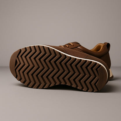 Sneaker marron couchée montrant sa semelle à chevrons et son liseré crème