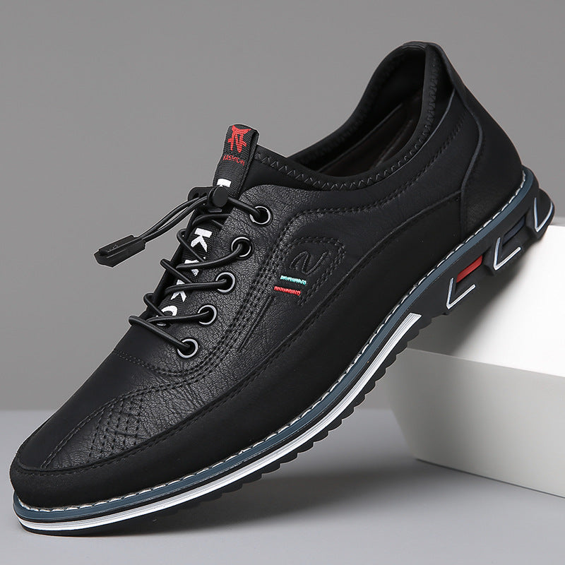 Sneaker basse en cuir noir appuyée sur un socle blanc, liseré bleu et blanc