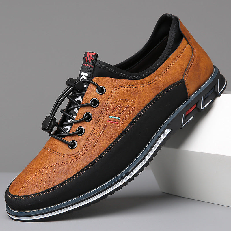 Paire de sneakers camel et noir, l'une posée sur un socle blanc, semelle crantée