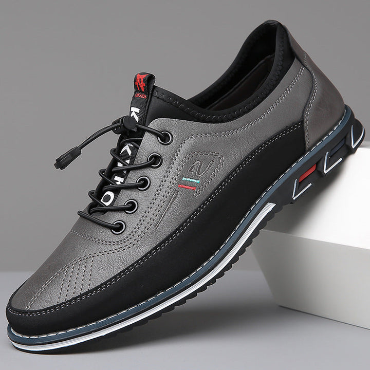 Sneaker basse en cuir gris et noir à lacets élastiques, semelle crantée