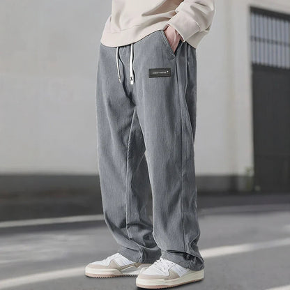 Pantalon en velours côtelé gris à cordon écru, coupe ample et baskets blanches