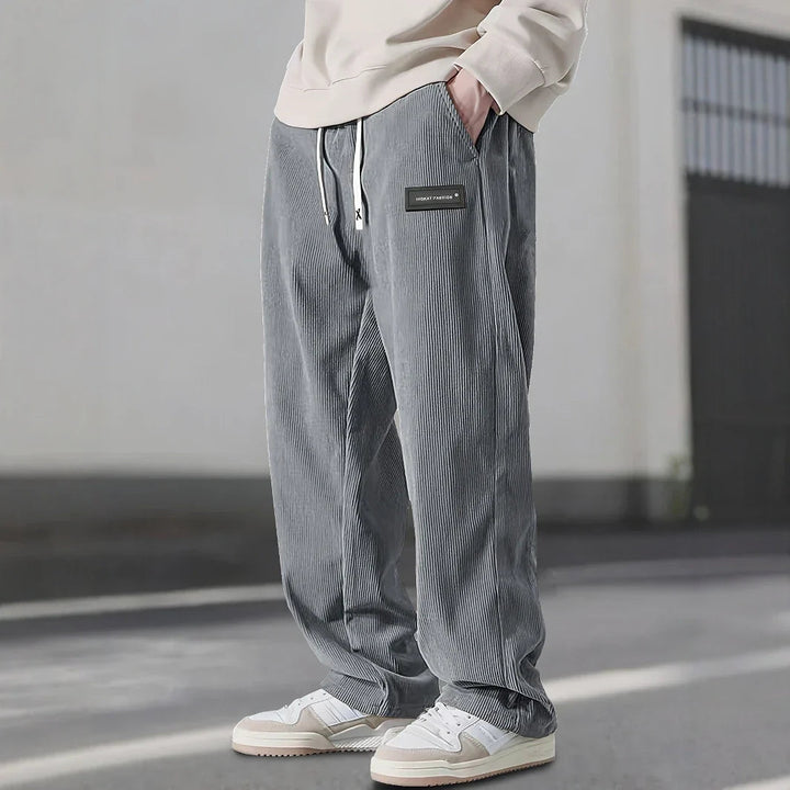 Pantalon en velours côtelé gris à cordon écru, coupe ample et baskets blanches