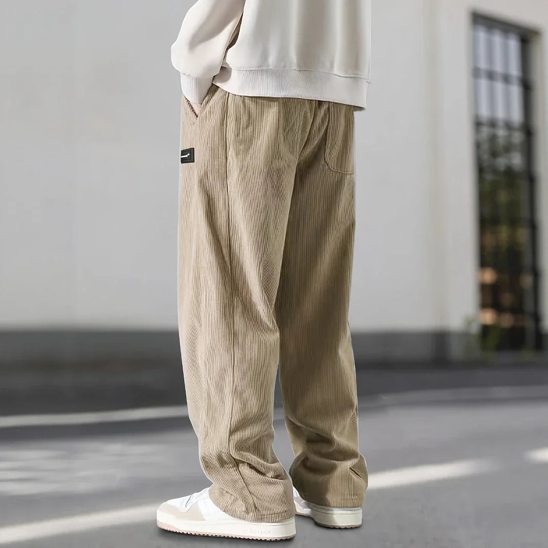 Pantalon en velours côtelé beige vu de profil, poche latérale et jambe fluide