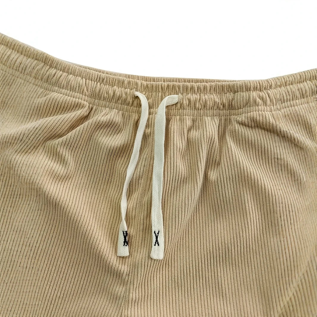 Gros plan sur la taille élastique beige et son cordon plat écru à embouts