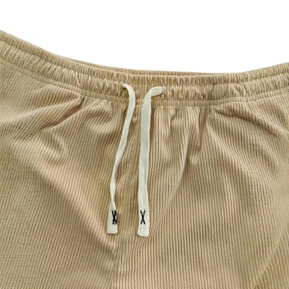 Gros plan sur la taille élastique beige et son cordon plat écru à embouts