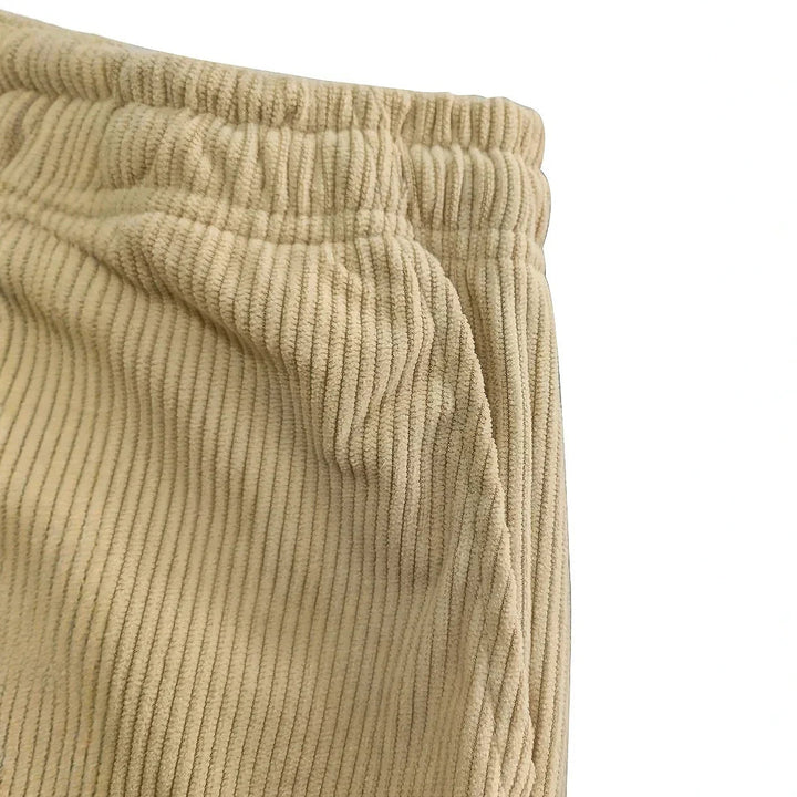 Gros plan sur la taille froncée et l'entrée de poche du velours côtelé beige