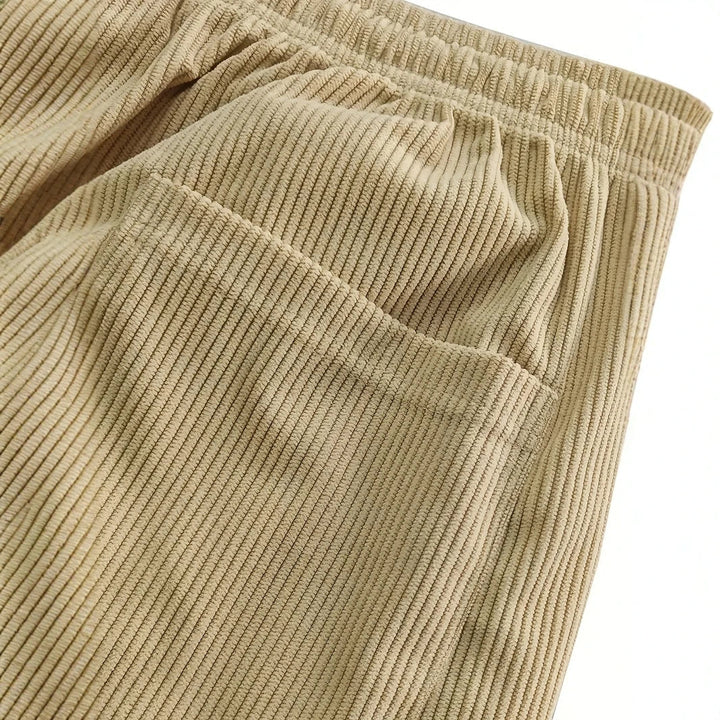 Gros plan sur la poche latérale du pantalon beige et la large côte du velours
