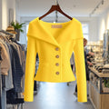 Veste en maille côtelée jaune à grand col et boutons dorés, sur cintre