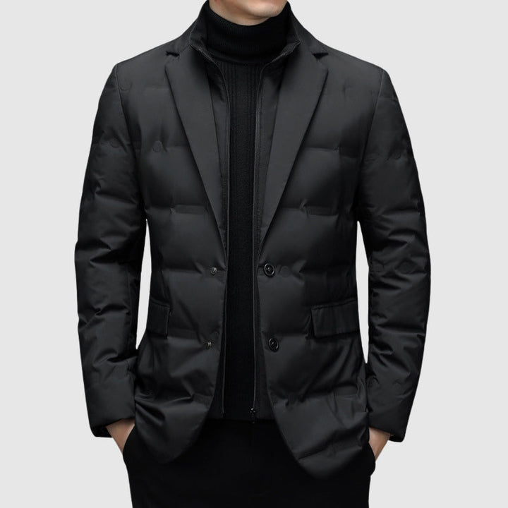Homme en veste matelassée noire à col cranté, portée sur un pull noir à col roulé