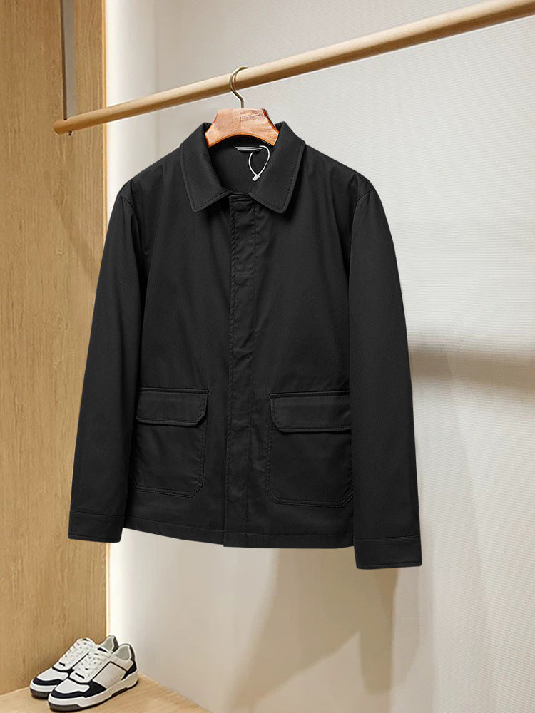 Veste noire a col chemise et poches a rabat, suspendue sur un cintre