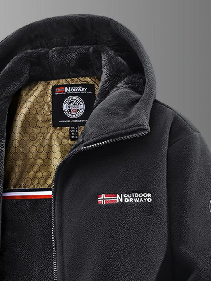 Gros plan sur le col noir de la veste polaire, zip argenté et doublure peluche