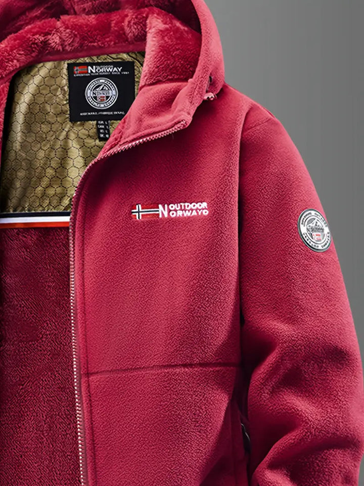 Gros plan sur le col rouge de la veste polaire, doublure peluche et logo brodé