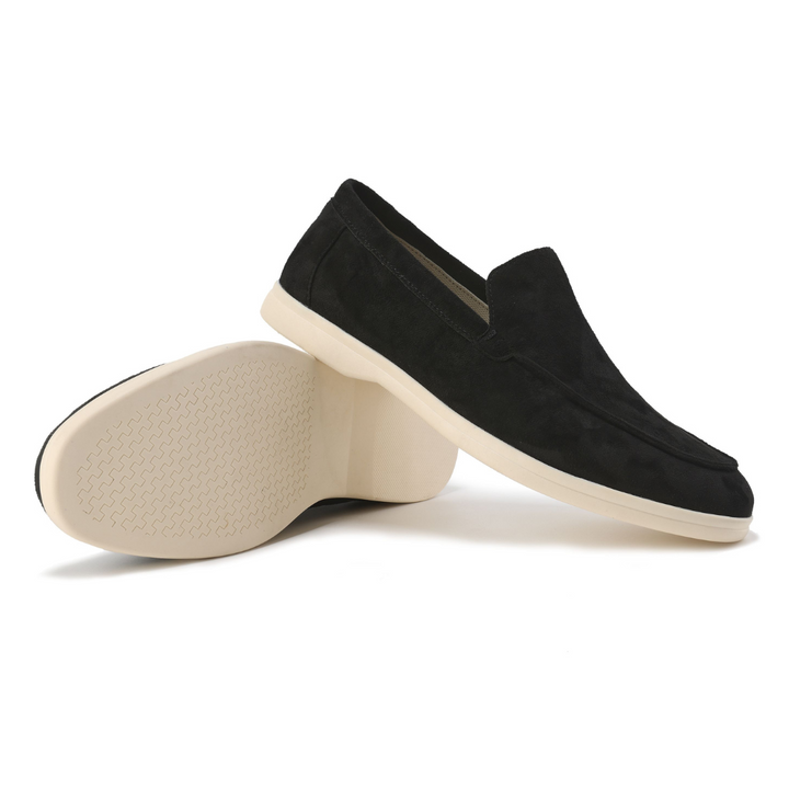 Mocassins en daim noir, l'un couché révélant la semelle crème à motifs